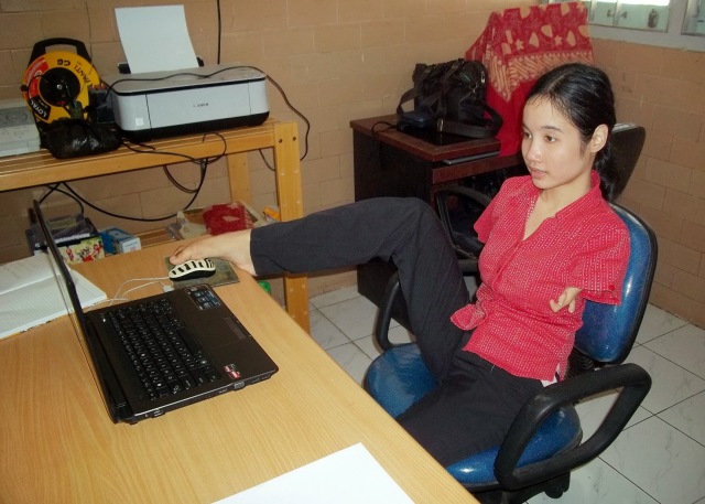Putri Herlina menggunakan komputer dengan kedua kakinya. (Sumber: http://saptuari.blogspot.com/2013/10/tuhan-maha-sutradara.html)